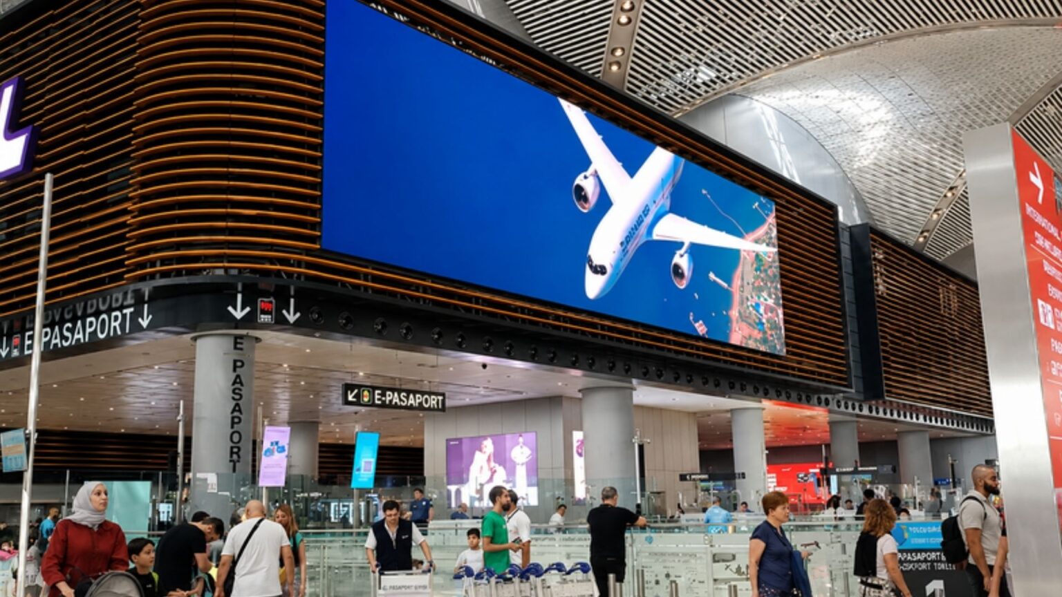 Best Zero Forex Credit Cards in India 2026 displayed on a digital airport billboard inside a modern international airport terminal, representing travel rewards, international spending, and forex-free travel credit cards.